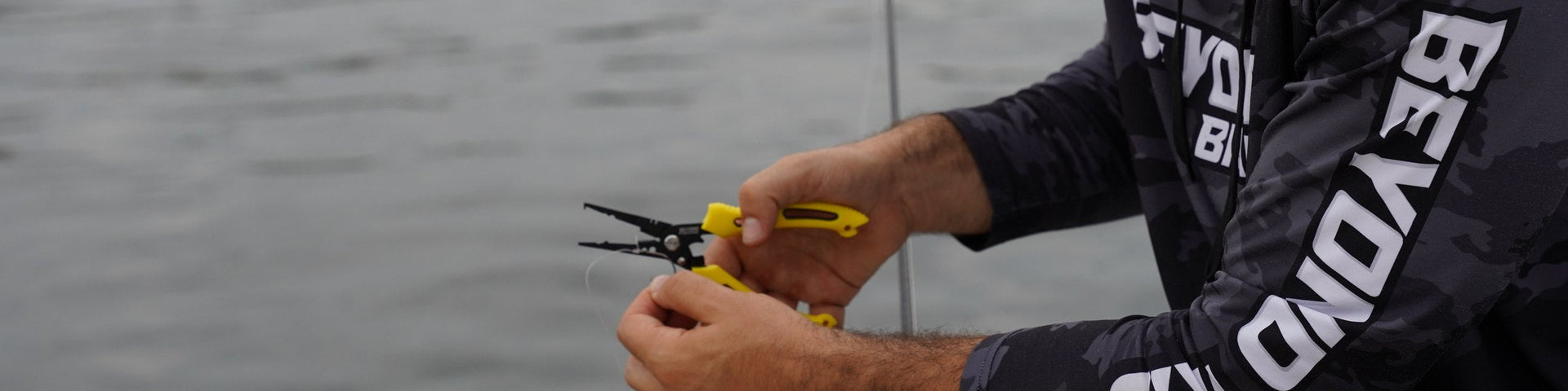 Angler using Beyond Braid pliers on the water